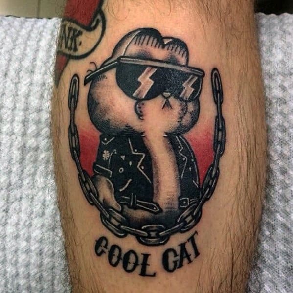 Garfield tattoo in a biker jacket, sunglasses, and surrounded by chains with 'Cool Cat' text—bold, rebellious design with attitude.