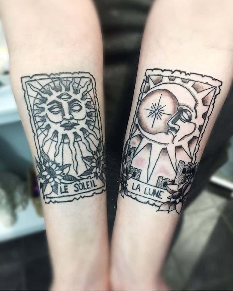Matching tarot card tattoos of 'Le Soleil' and 'La Lune,' featuring hand-drawn sun and moon designs with floral details on the forearms.