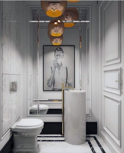 Stylish half-bath with cylindrical sink, statement lighting, and large wall art.