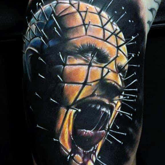 Realistic *Hellraiser* tattoo of Pinhead screaming, featuring bold colors, deep shading, and intricate pin details for an intense and haunting design.