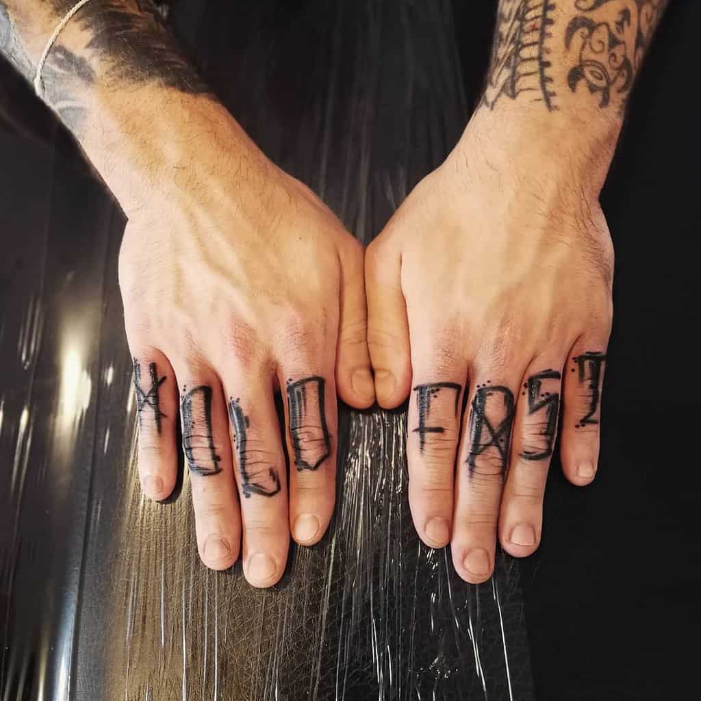 Hands with "HOLD FAST" tattoos on fingers