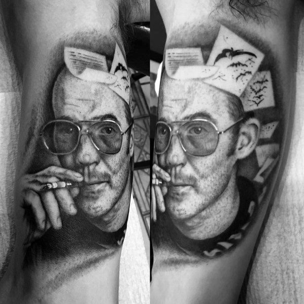 Black and white Hunter S. Thompson tattoo featuring a highly detailed portrait with aviator glasses, a cigarette, and papers flying from his head with bats.