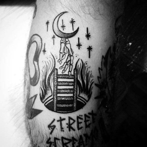 Bold tattoo of a rope ladder rising from flames toward a crescent moon, symbolizing overcoming challenges, ideal for men's thighs or arms.