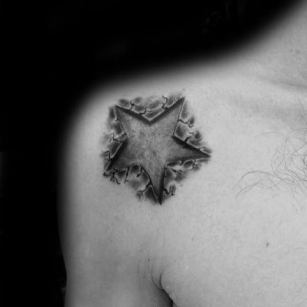 3D star tattoo on shoulder with cracked skin shading, giving the illusion that the star is embedded beneath the surface.