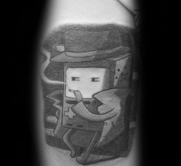 Black and grey Adventure Time tattoo of BMO in a noir detective outfit, smoking with a relaxed expression, inked on the arm.