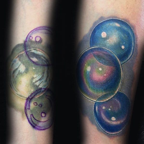 Tattoo of vibrant, realistic bubbles in various sizes, with colorful reflections and a soft gradient effect, creating a dynamic, three-dimensional design.