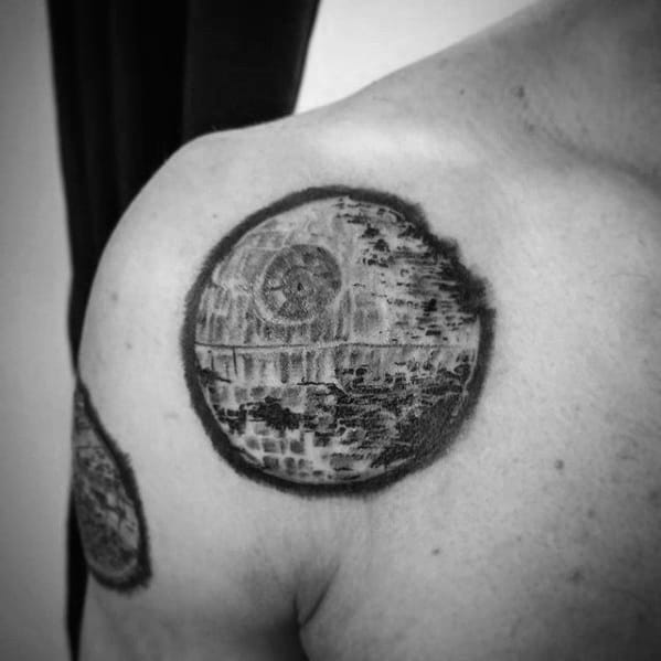 Black and gray tattoo of the Death Star on a person's shoulder