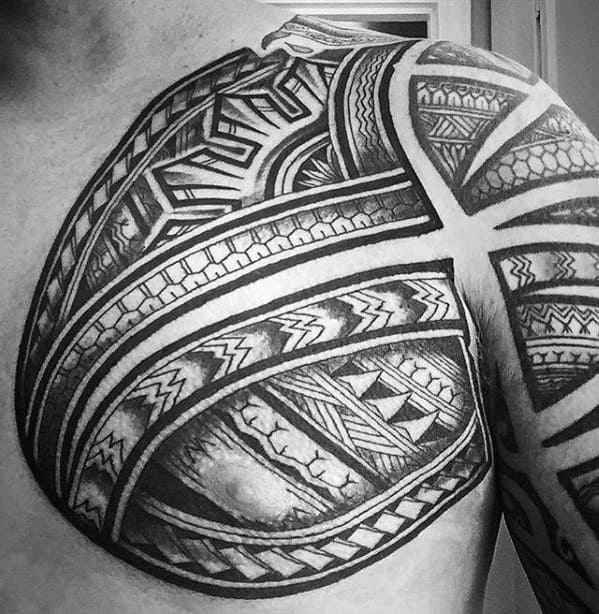 Filipino tribal chest and shoulder tattoo with bold intersecting bands, intricate geometric patterns, and detailed textures creating a cohesive design.