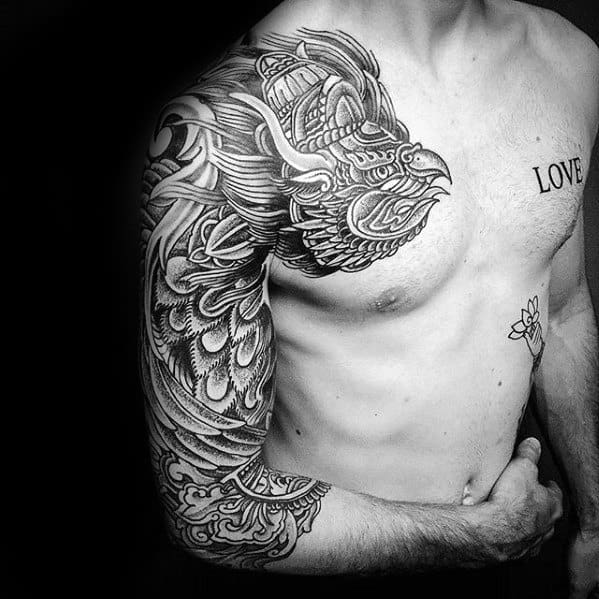 Garuda tattoo design with bold feathers and a fierce beaked face, covering the shoulder and upper arm with detailed blackwork.
