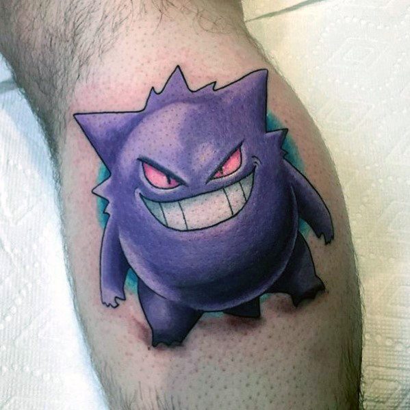 Vibrant Gengar tattoo with detailed shading, glowing red eyes, and a wide grin, set against a soft teal-blue background glow.
