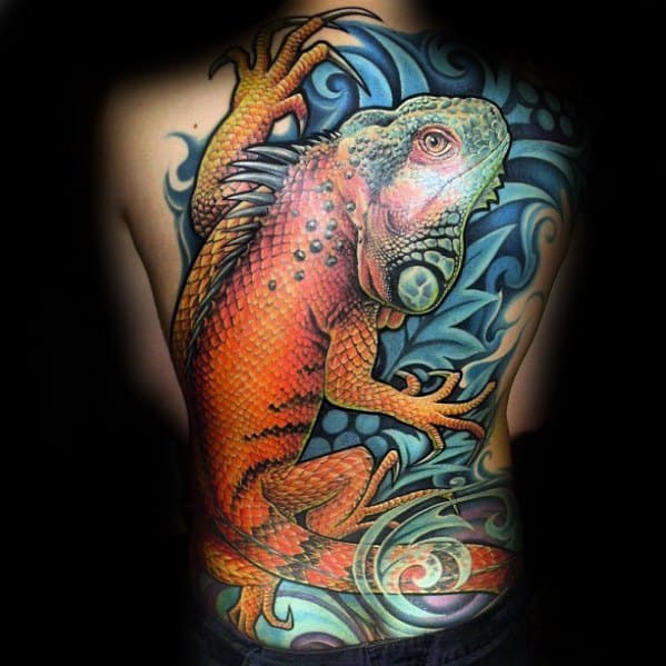 Vibrant full-back iguana tattoo in bold orange and red tones, set against a swirling blue abstract background with dynamic movement.