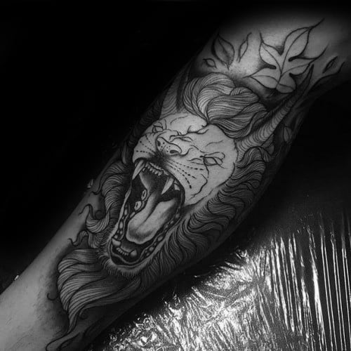 Black and grey neo-traditional roaring lion tattoo with flowing mane and leaf accents for a fierce yet artistic forearm design.