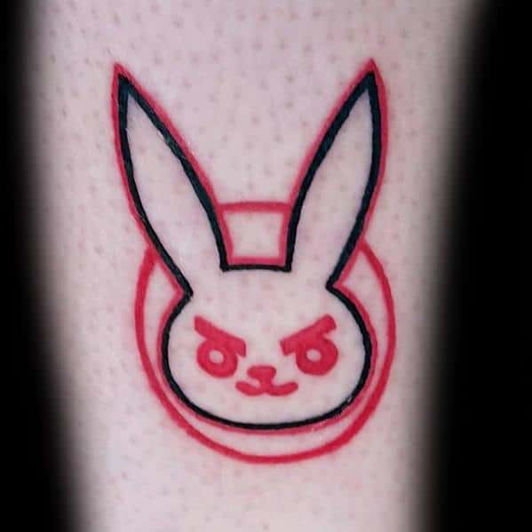 Minimalist tattoo of D.Va’s bunny logo from Overwatch, outlined in black with a red glow effect on the leg.