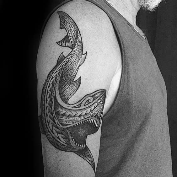 Polynesian shark tattoo on upper arm with detailed tribal patterns and bold shading symbolizing power, protection, and ocean connection.