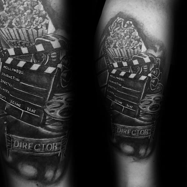 Realistic black and grey tattoo of a movie scene setup with a popcorn bucket, film reels, clapperboard, and a DIRECTOR chair.
