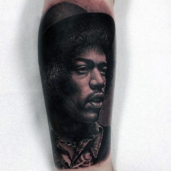 Realistic tattoo of Jimi Hendrix in profile with detailed shading and afro hairstyle