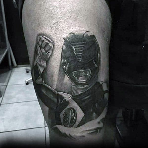 Black and grey tattoo of the Black Ranger in a powerful raised-fist pose, featuring detailed shading and realistic armor texture.