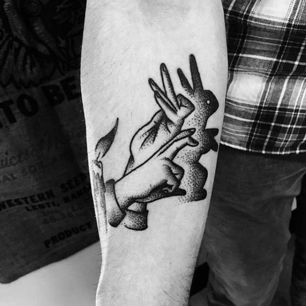 Blackwork tattoo of hands forming a rabbit shadow puppet, symbolizing childhood playfulness, imagination, and creative expression.