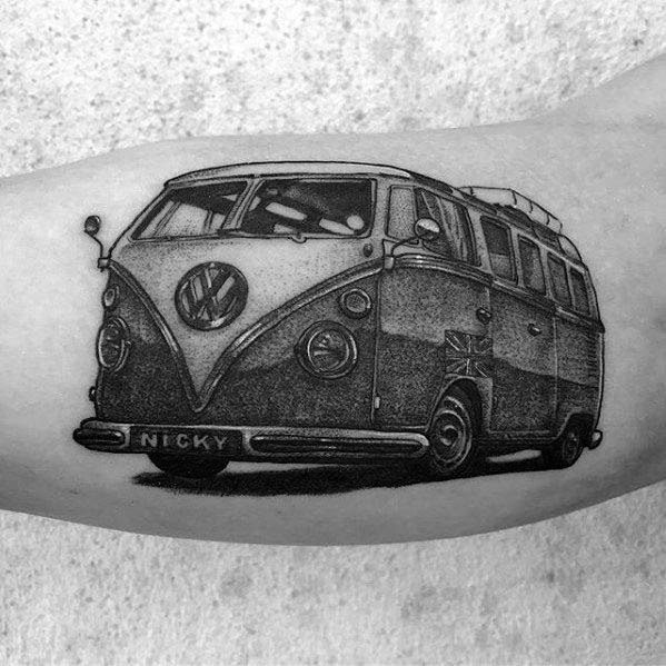 Detailed black and gray tattoo of a Volkswagen van with "NICKY" on the license plate, inked on the inner arm with fine shading.