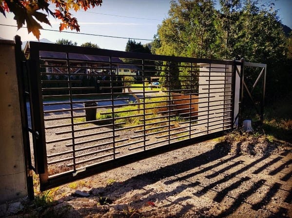 Modern metal driveway gate with horizontal bar design.