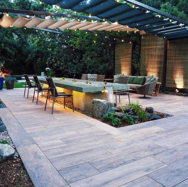 Steel pergola with fabric canopy, string lights, and an elegant dining setup.
