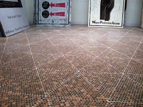 Intricate geometric pattern on a penny floor, featuring aligned white grout for a striking design.