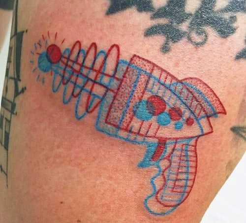 Unique 3D-style ray gun tattoo with overlapping red and blue lines, creating a retro sci-fi effect reminiscent of vintage anaglyph imagery.