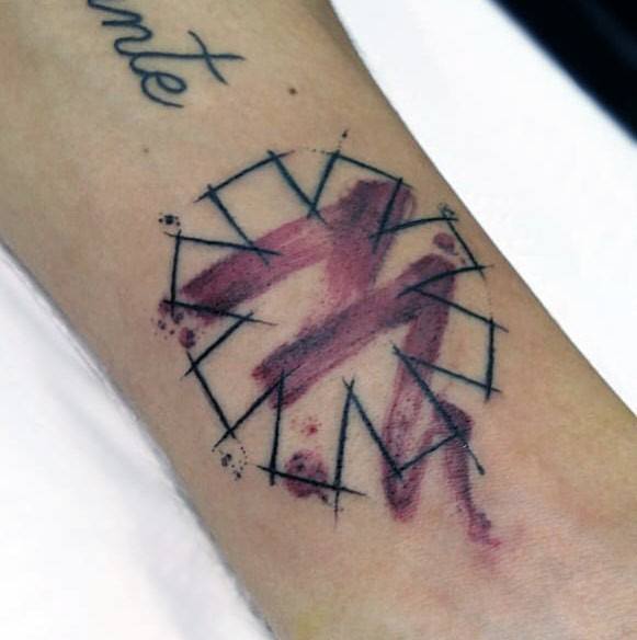 Tattoo featuring the Red Hot Chili Peppers logo with a watercolor brushstroke effect and abstract black line details for a modern artistic look.