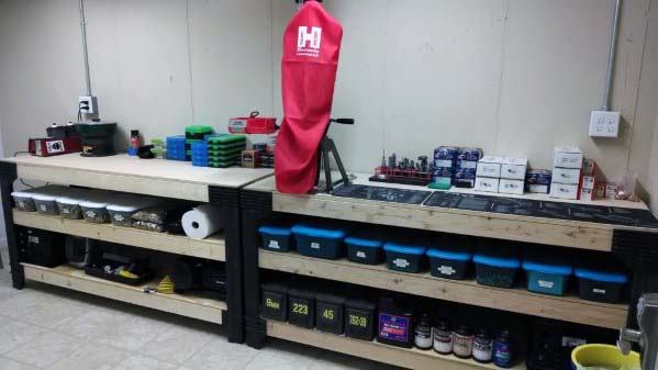 Spacious reloading bench with sturdy wooden construction, featuring organized storage bins and shelves for ammunition, tools, and powders. A protective cover for the press adds a clean, professional look, while the layout maximizes functionality and workspace efficiency.
