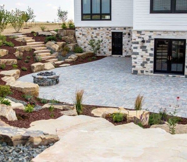 House with stone driveway, landscaped garden, and stone steps