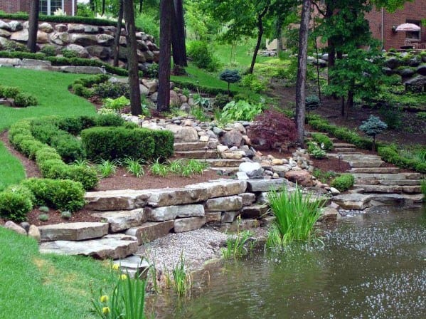 Terraced garden with stone steps and lush greenery beside a tranquil pond