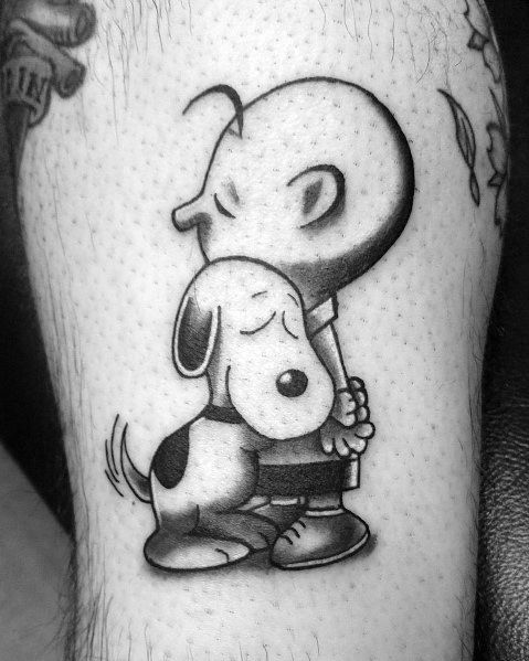 Black and white tattoo of Charlie Brown and Snoopy sharing a heartfelt hug, with soft shading for depth, placed on a person's leg.