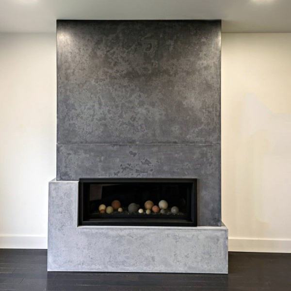Minimalist concrete fireplace with a textured finish and decorative stone accents inside.