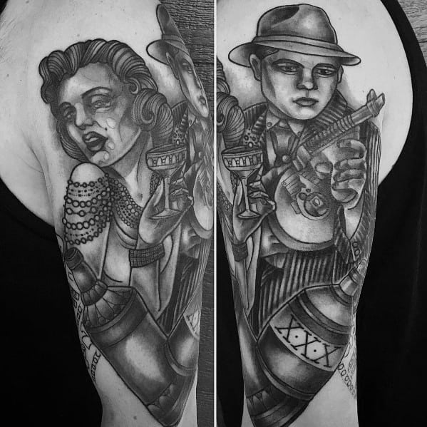 Black and grey gangster-themed tattoo featuring a mobster with a Tommy gun and a flapper-style woman holding a drink, with intricate shading and vintage aesthetics.