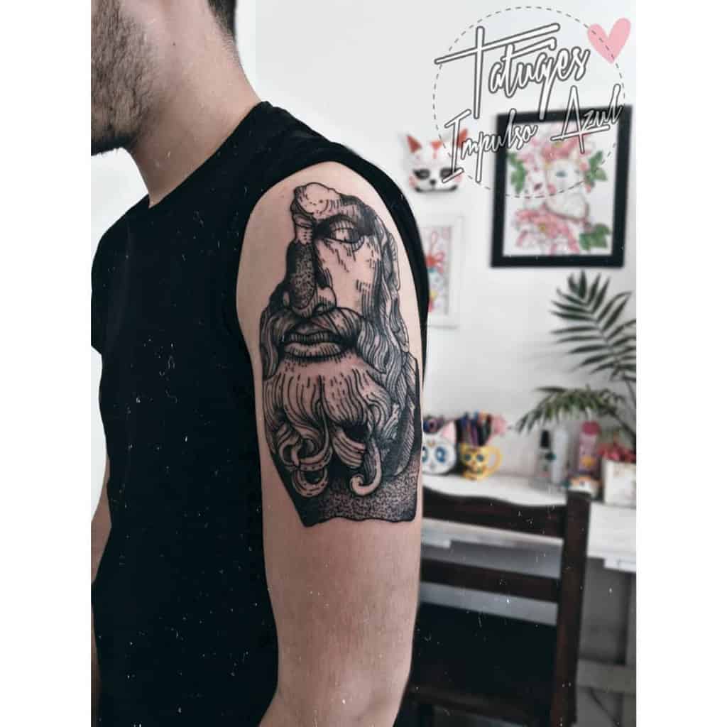 Man with a detailed tattoo of a bearded figure on his upper arm
