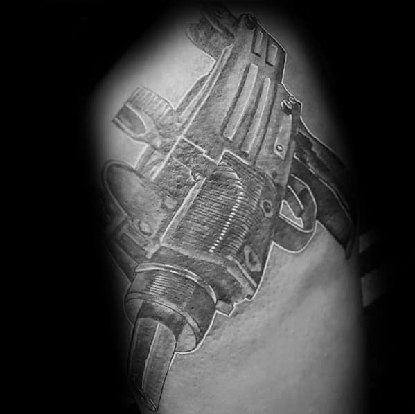 Realistic black and grey Uzi tattoo with detailed shading and depth, creating a bold and lifelike firearm design on the skin.