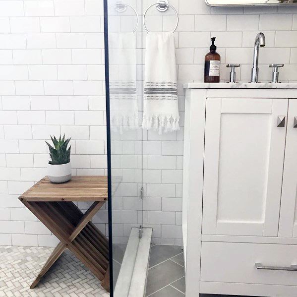 White minimalist bathroom with modern sink and wooden shelf holding a potted plant