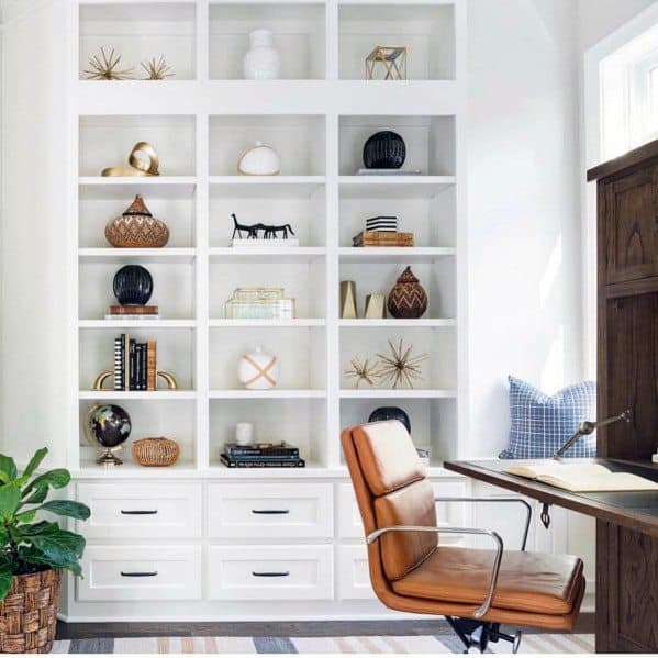 A stylish home office with a cozy nook, leather chair, and wooden desk
