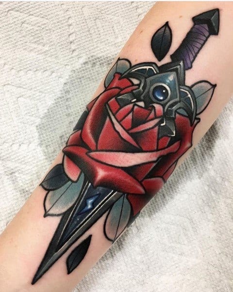 Tattoo of a World of Warcraft-inspired sword piercing through a red rose, featuring bold colors, intricate shading, and a fantasy-style design, inked on the forearm.