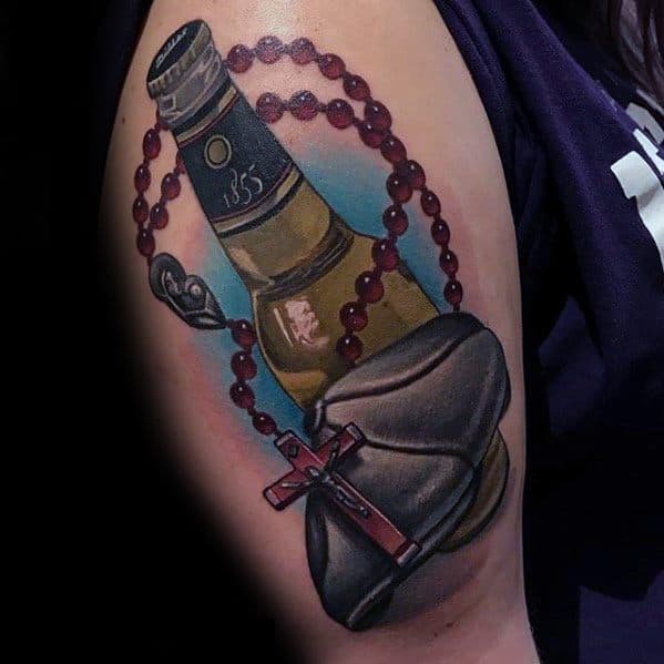Vivid upper arm tattoo of a beer bottle wrapped in a red rosary with a cross and monk's hood, blending religious symbolism with drinking culture.