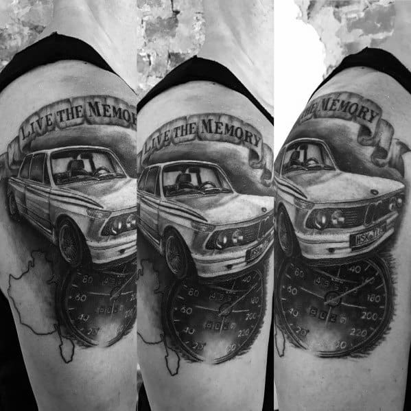 Realistic BMW E21 tattoo on upper arm, featuring a speedometer, map, and 'Live the Memory' banner for a nostalgic automotive design.