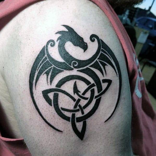 Tattoo of a black dragon interwoven with a Celtic knot on an upper arm