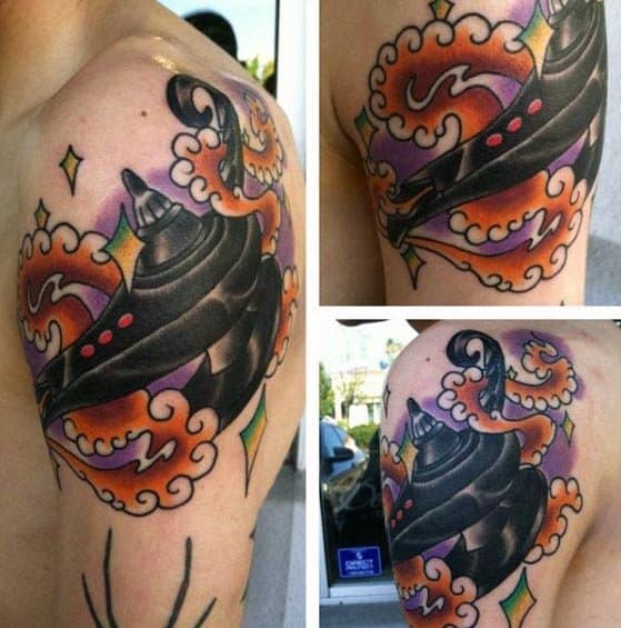 Colorful tattoo of a spinning top and a genie lamp with swirling patterns on a shoulder