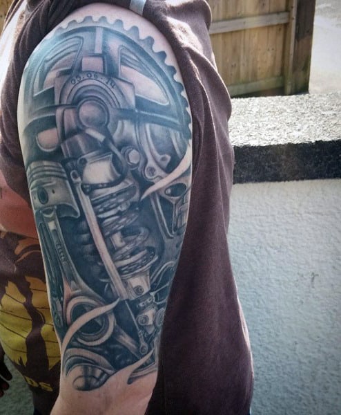 Tattoo sleeve on left arm featuring detailed gears and mechanical parts