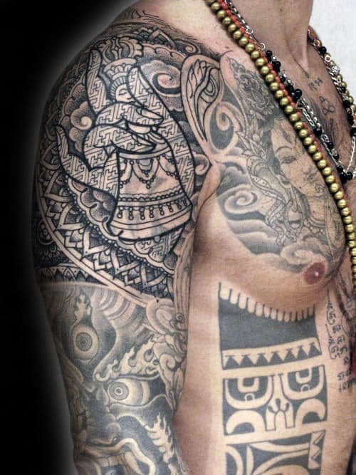 Intricate black tribal tattoos with a striking blast-over on the arm, shoulder, and chest
