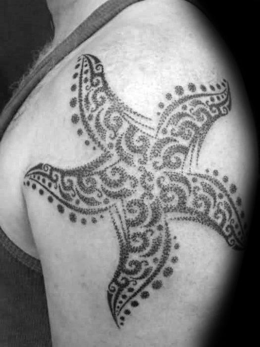Large black ink starfish tattoo on the upper arm, filled with ornate dotwork and swirling mandala-inspired patterns.