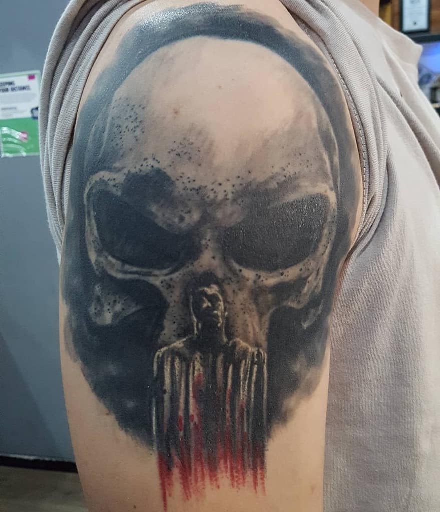 Tattoo of a Punisher Skull, dripping with red and black ink on an upper arm