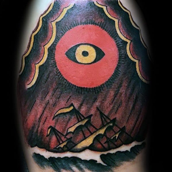 Bold traditional-style tattoo of a shipwreck under a stormy sky, with a large red eye above symbolizing fate or divine watchfulness.