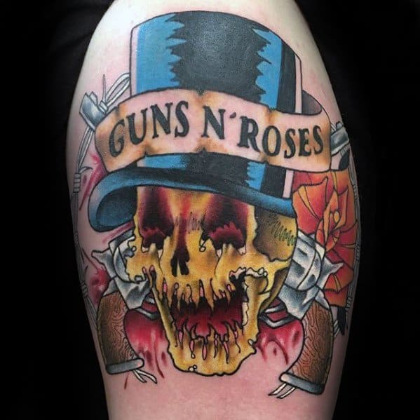 Bold tattoo of a melting yellow skull in a blue top hat with "Guns N' Roses" banner, crossed pistols, and an orange rose.
