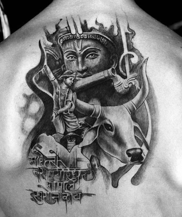 Bold black and grey Shiva-themed back tattoo featuring Lord Shiva’s face, trident, bull Nandi, archer figure, and Sanskrit script at the bottom.